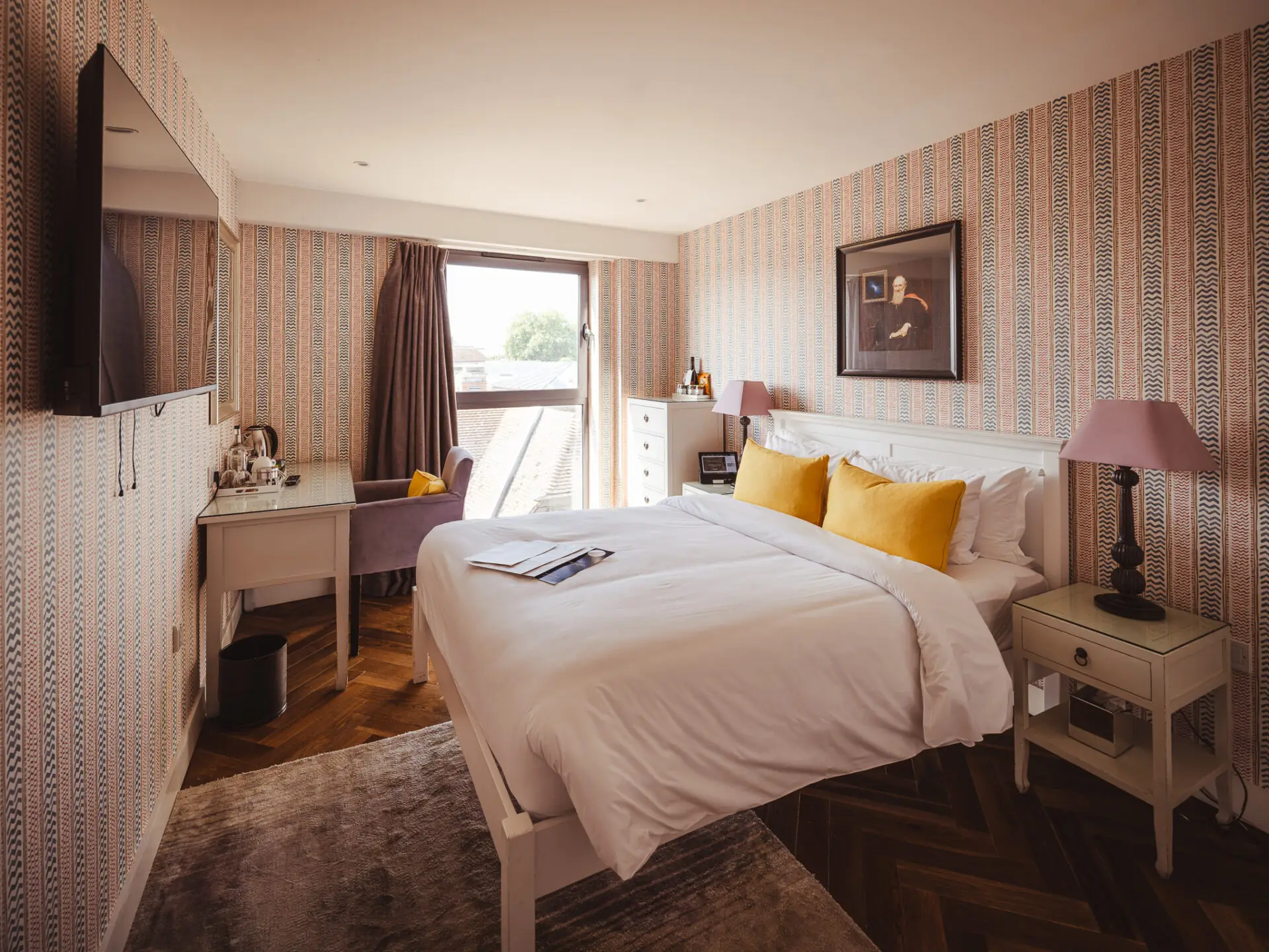 hotel bedroom with loud wallpaper and yellow cushions