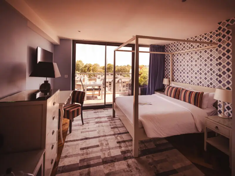 hotel room with large geometric rug and purple accents