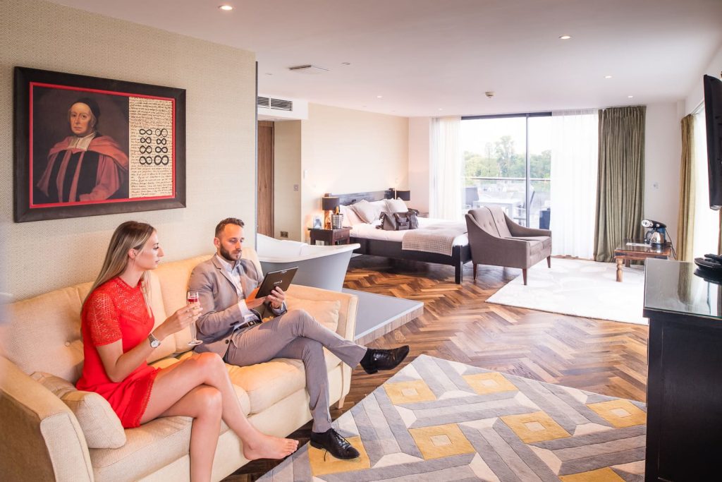couple in hotel dressed ready to go out, looking at the menu