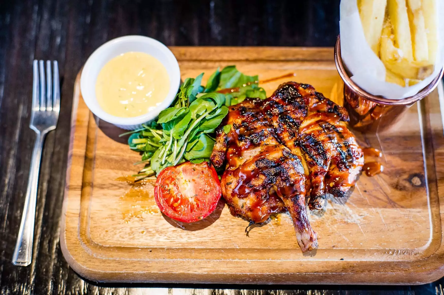 half a chicken with chips in a tin