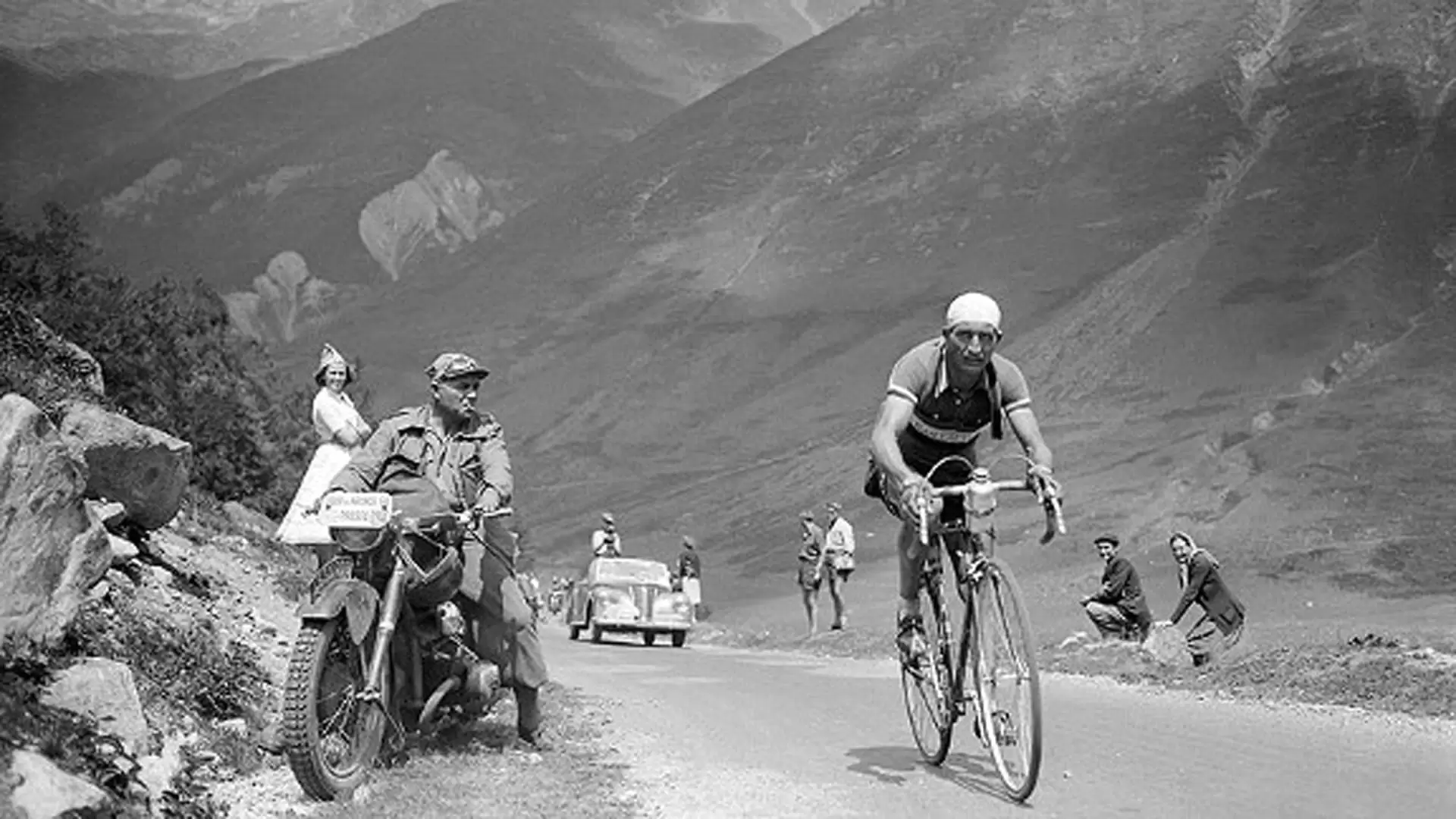 Black and white photo of a man on a bike