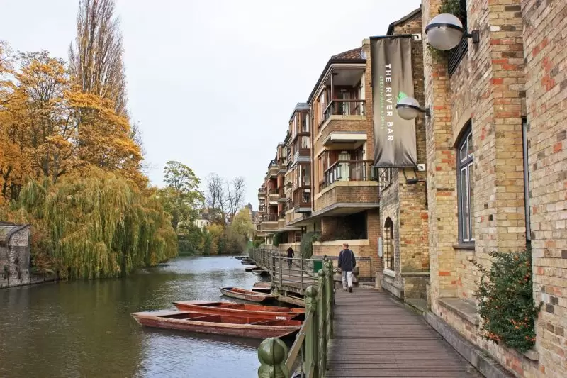 someone walking outside the river bar next to the river cam