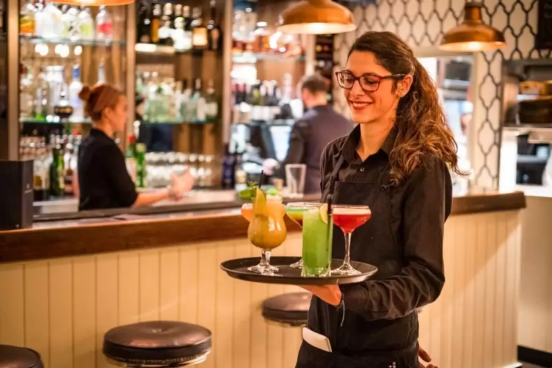 waitress holding tray filled with five cocktails