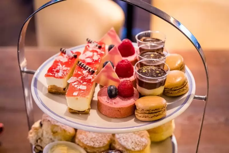 top of afternoon tea with cheesecakes macaroons and other sweet treats