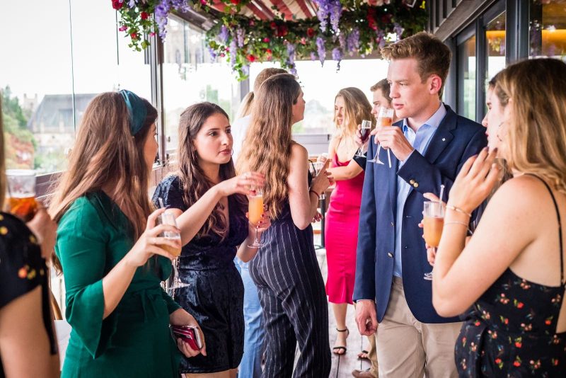 group of friends on the balcony of six restaurant talking and drinking bellinis