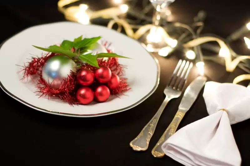 plate with a baubles and tinsel on with knife and fork to the side for new years eve