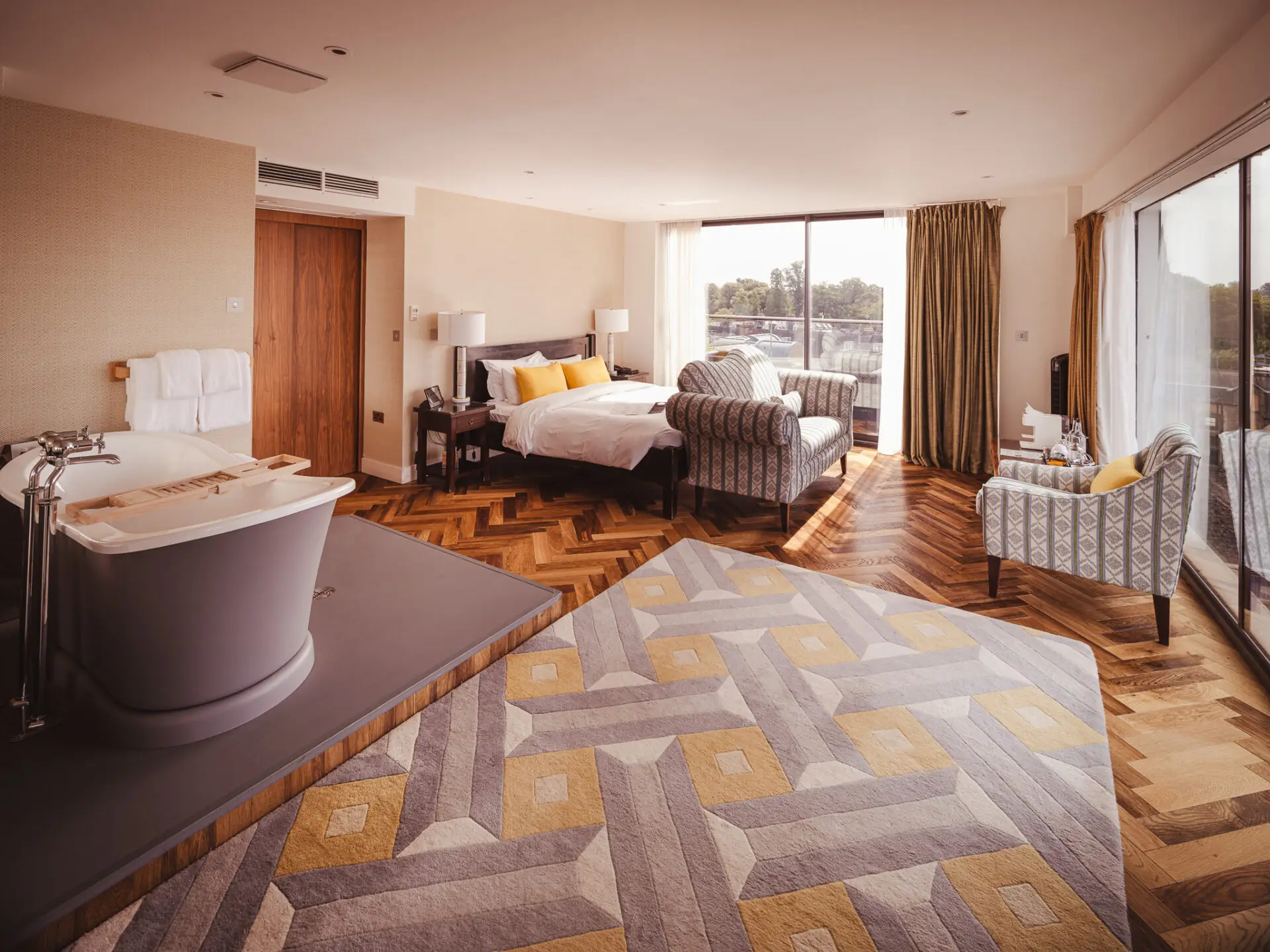 beautiful hotel room with roll top free standing bath and view of cambridge with bright yellow features